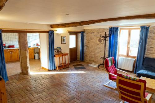 un salon avec des rideaux bleus et une table et des chaises dans l'établissement Gite La Petite Maison - au coeur des vignes - Mercurey, à Saint-Martin-sous-Montaigu