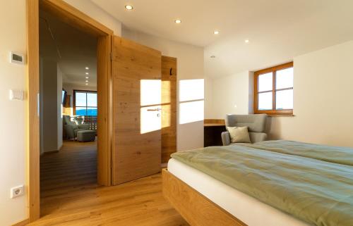 a bedroom with a large bed and a chair at Lenzlhof in Mariapfarr