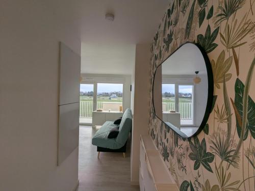a mirror on a wall in a living room at Studio Les Capucines in Bretteville-sur-Odon