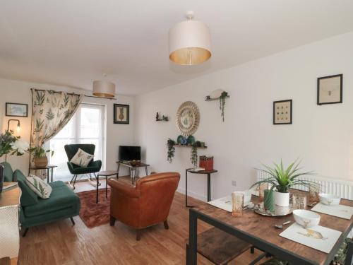 a living room with a table and chairs at Cotswold Outlet Coach House in Tewkesbury