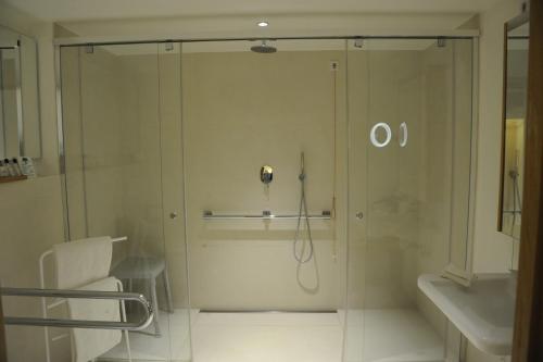 a shower in a bathroom with a phone on the wall at Hotel Bora HotSpaResort in Radolfzell am Bodensee