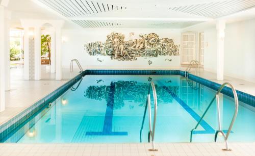 a swimming pool in a house with a painting on the wall at Berghotel Hoher Knochen - Ruhe & Natur in Winterberg