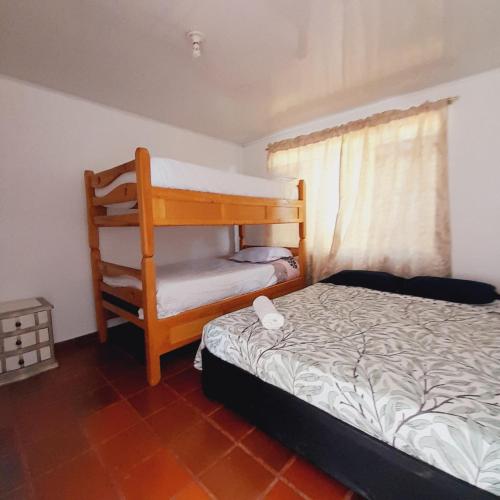 a small bedroom with a bunk bed and a window at Casa Campestre Encanto Rural in Anolaima
