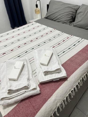 a bed with two towels sitting on top of it at Bianco 305 in Angeles