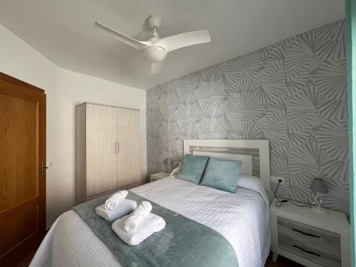 Un dormitorio con una cama con toallas. en La Escapadita, en Benaoján