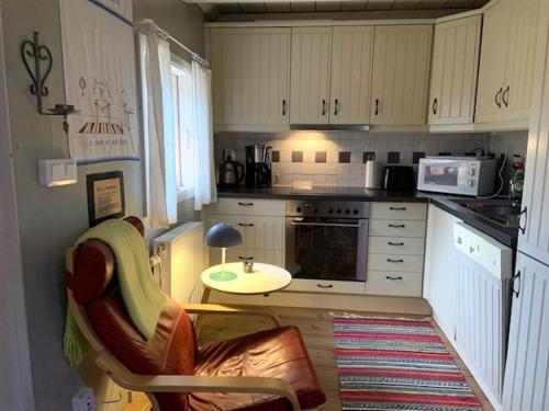 a kitchen with white cabinets and a table in it at Naturnära på Ängaröds 1700-tals gård in Ljungbyhed