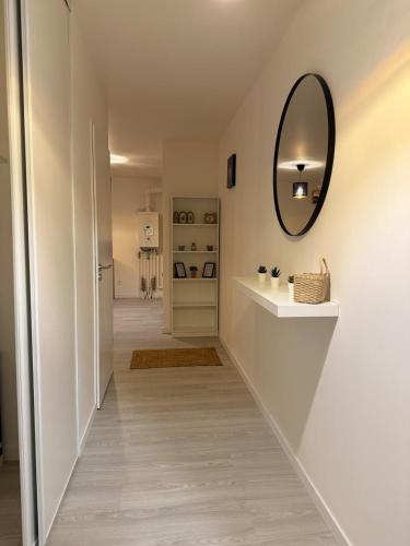 - un couloir avec un miroir mural et un lavabo dans l'établissement Apt Neuf Centre Saint-sever, à Rouen