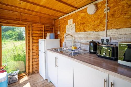 a kitchen with a stove and a counter top at Daisy at Blancas Bell Tents in Ringstead
