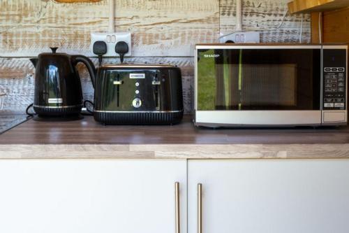 a microwave sitting on top of a kitchen counter at Daisy at Blancas Bell Tents in Ringstead