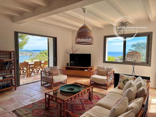 un salon avec un canapé, des chaises et une télévision dans l'établissement Villa La Sarrazine - Port du Niel - Vue Mer, à Hyères