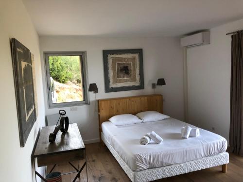 une chambre avec deux lits et une table et une fenêtre dans l'établissement Villa La Casuccia, à Porto-Vecchio