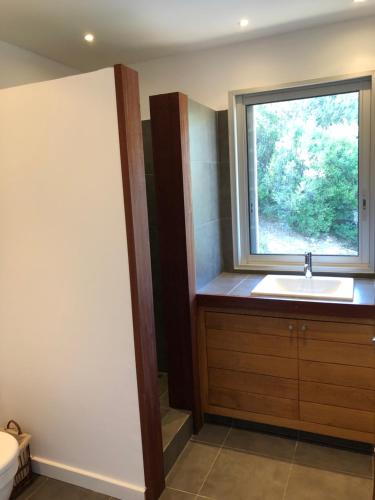 une salle de bain avec un lavabo et une fenêtre dans l'établissement Villa La Casuccia, à Porto-Vecchio