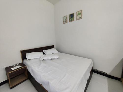 a bedroom with a bed with white sheets and pillows at 2BHK Cliff Side Villa in Mount Ābu