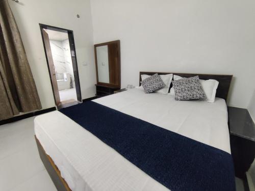 a bedroom with a large bed with blue and white sheets at 2BHK Cliff Side Villa in Mount Ābu