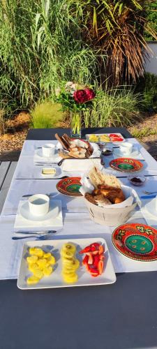 une table avec de nombreuses assiettes de nourriture dessus dans l'établissement B&B Les Villas de Gascogne, à Lanton