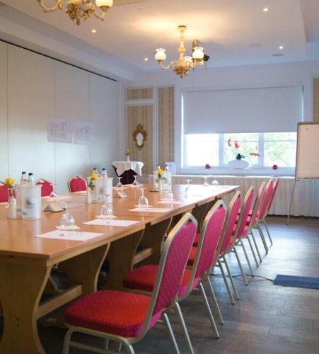a large table with chairs and a long table in a room at Fürstenhof Landgasthaus & Hotel in Erfurt