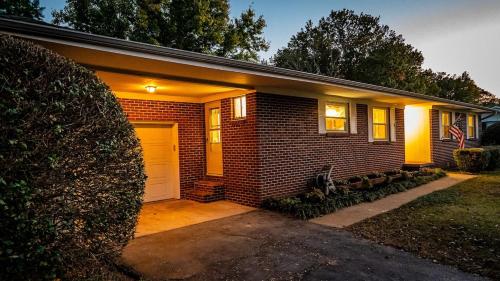 a brick house with a white garage and an american flag at Amazing House Hot Tub Mins To Major Hospitals in Middle Valley