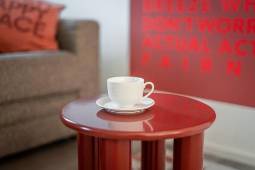 a coffee cup sitting on a red table at Lebe`schlitters - Das Ferienapartmenthaus im Zillertal in Schlitters