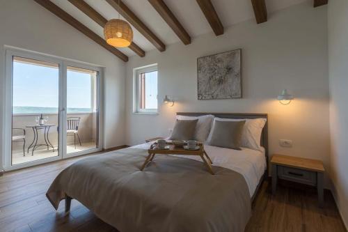 a bedroom with a large bed with a table on it at Villa Skarline in Donje Baredine