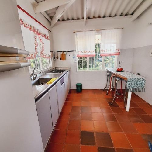 a kitchen with a sink and a table in it at Casa Campestre Encanto Rural in Anolaima