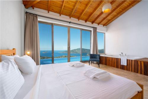 ein Schlafzimmer mit einem großen weißen Bett und ein Badezimmer in der Unterkunft Akasya Villas in Kalkan