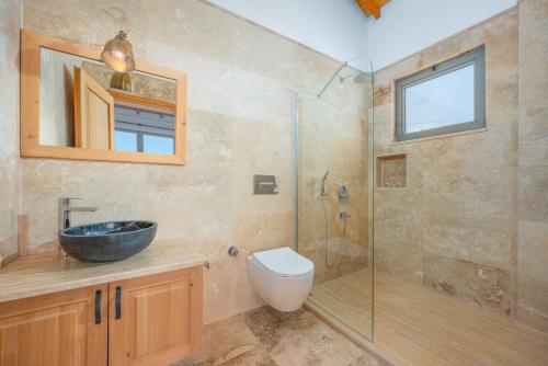 ein Badezimmer mit Waschbecken und Glasdusche in der Unterkunft Akasya Villas in Kalkan