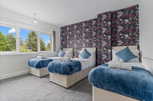 zwei Betten in einem Zimmer mit zwei Fenstern in der Unterkunft Luxury Birmingham Solihull Spacious Home - Driveway - Groups of 8 Max - 3 Bedrooms 4 or 6 Beds Fully Equipped Home - Near City Centre NEC HS2 Sites Edgbaston Moseley& lots more! in Birmingham