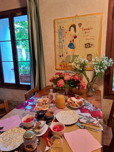 a table with plates of food and flowers on it at Casadesergio in Refrontolo