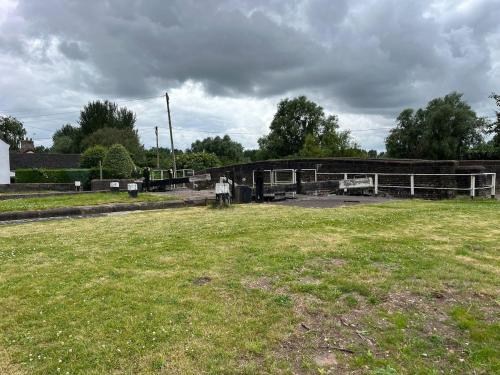 a person standing in a field in front of a building at Paddle Gate Cottage in Sandbach