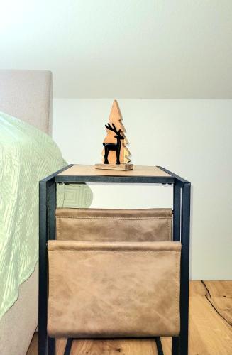 a bedside table with a figurine of a cat on it at Heimatliebe Neuried 20 Min zum Europa-Park in Neuried