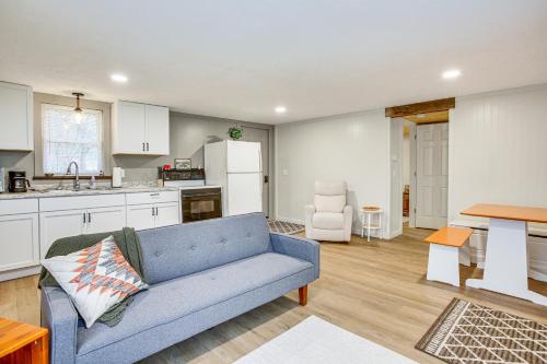 a living room with a blue couch and a kitchen at Updated Wellston Cabin, Walk to Lake Beach and Dock! in Irons
