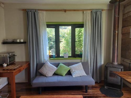 a living room with a couch and a window at Hostal Pirineos in Valdivia