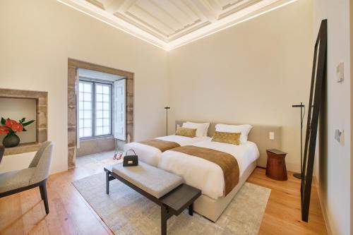 a white bedroom with a large bed and a table at MS Collection Arouca - Mosteiro de Arouca in Arouca