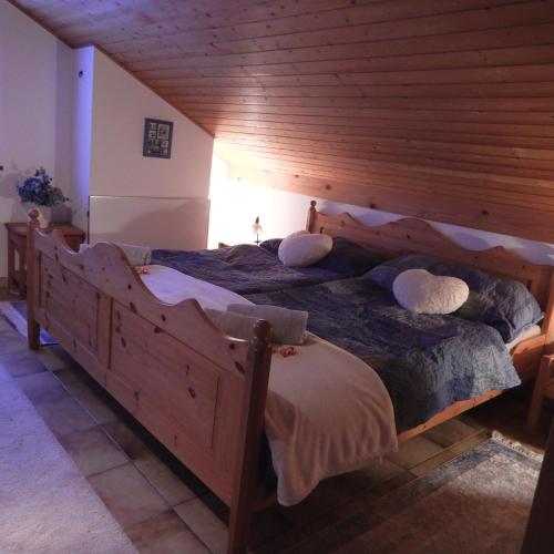 a bedroom with a large wooden bed with pillows at Cuore Verde Apartment in Gerra Verzasca