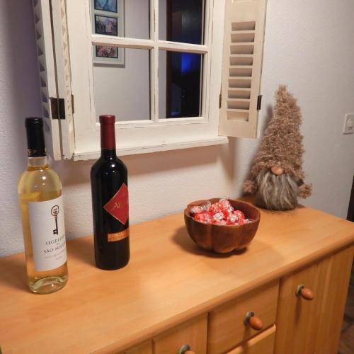 a bottle of wine and a bowl of crystals on a counter at Cuore Verde Apartment in Gerra Verzasca