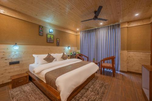 a bedroom with a large bed and a ceiling fan at The Nature Dreams l Private Balconies l 360" Mountain View l Room Service l Business Centre l Apple Orchid for Morning and Evening Walk l Kufri by Exotic Stays in Kūfrī