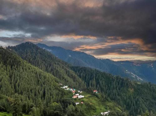 a view of a mountain with trees and houses at The Nature Dreams l Private Balconies l 360" Mountain View l Room Service l Business Centre l Apple Orchid for Morning and Evening Walk l Kufri by Exotic Stays in Kūfrī