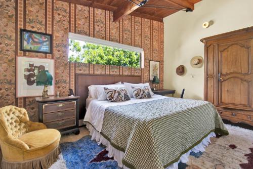 a bedroom with a bed and a window and a chair at The Leona in Lockhart