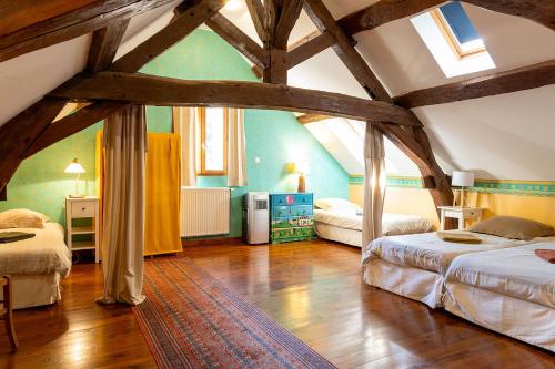 une chambre avec deux lits et un plafond avec poutres dans l'établissement Gite La Petite Maison - au coeur des vignes - Mercurey, à Saint-Martin-sous-Montaigu