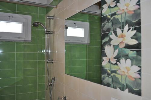 a green tiled bathroom with a shower with a mirror at Affittacamere Elisa in Pisa