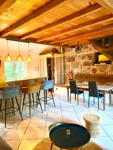 a room with a bar with chairs and a table at Quinta de Ribas in Amarante