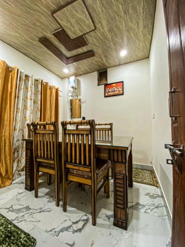 a dining room with a wooden table and chairs at Scenic Village Stay near Kufri With Bonfire & Veg Meals-Alpine Crest Homestay Kufri in Theog