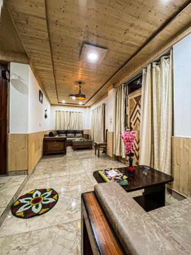 a living room with a couch and a table at Scenic Village Stay near Kufri With Bonfire & Veg Meals-Alpine Crest Homestay Kufri in Theog