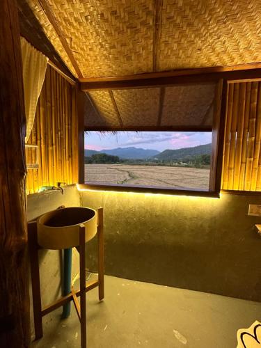 a bathroom with a window with a sink and a table at เฮือนจินดา Jins BANN Lhongkao in Ban Wang Masiu
