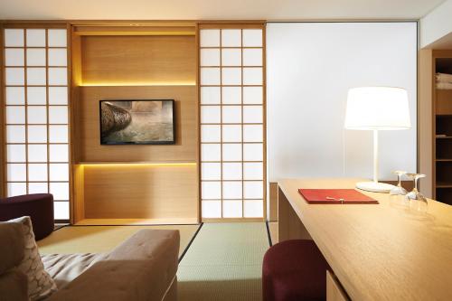 an office with a desk and a chair and a lamp at Hotel Bora HotSpaResort in Radolfzell am Bodensee