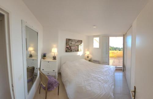 une chambre blanche avec un lit et un miroir dans l'établissement Seaview house, close Cannes, pool, garden. garage, à Théoule-sur-Mer