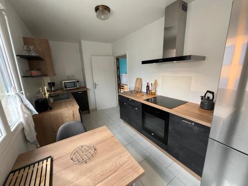 - une cuisine avec une table en bois et un comptoir dans l'établissement T3 au centre-ville à Belfort, à Belfort