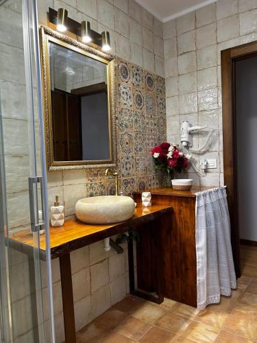 a bathroom with a sink and a mirror at El tejo milenario in Requejo
