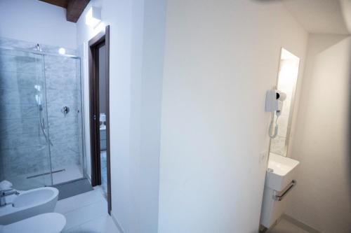 a white bathroom with a shower and a sink at B&B l'AMERIGO in Civitanova Marche