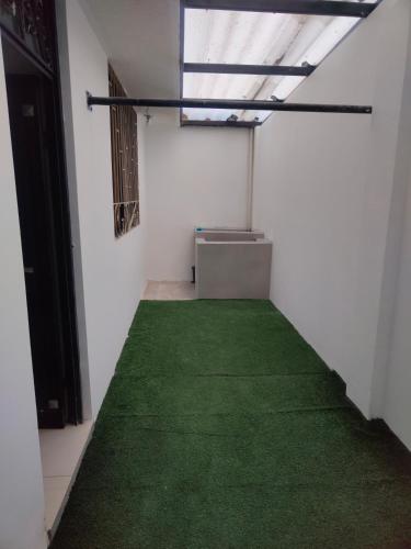a room with a green carpet on the floor at Roca Luminosa, Cine in Riobamba